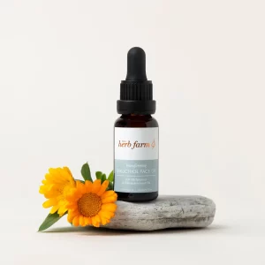 Bottler of Herb Farm Bakuchiol Face Oil 20ml sitting on a stone with some flowers next to it