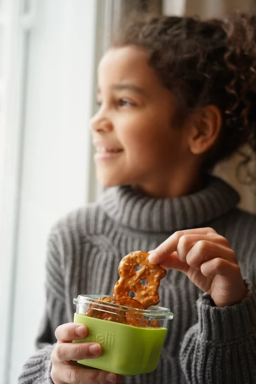 Girl pulling a pretzel from one of the Melii glass containers