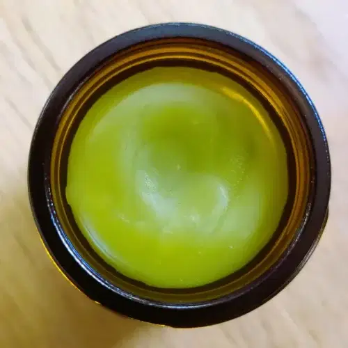 Looking into a container of Nature Body Kawakawa Balm 30g with the lid off.