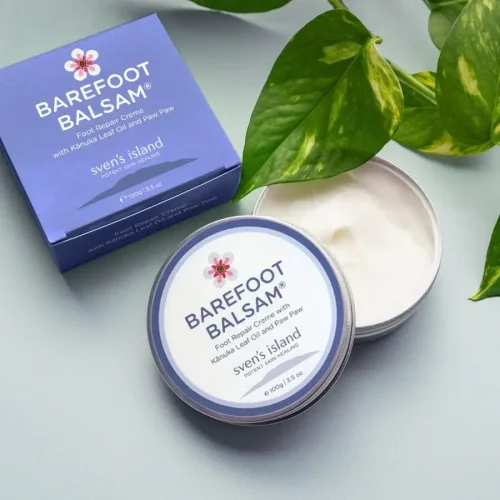 Open container of Made In New Zealand Using Natural Ingredients Barefoot Balsam - Foot and Leg Repair Cream on a table next to its packaging