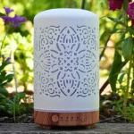 Zurma Diffuser Mandala Glow on a table with greenery in the background