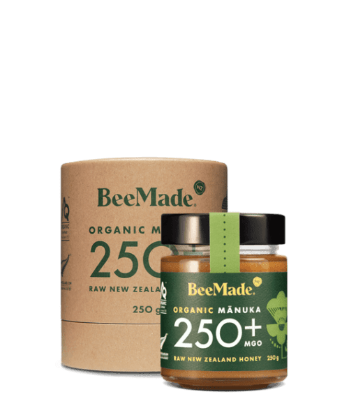 A jar of Beemade Manuka Honey 250+ 250g in front of its packaging