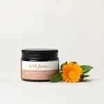 HerbFarm Hand Cream Almond Softening 50ml next to a calendula flower