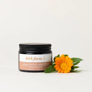 HerbFarm Hand Cream Almond Softening 50ml next to a calendula flower