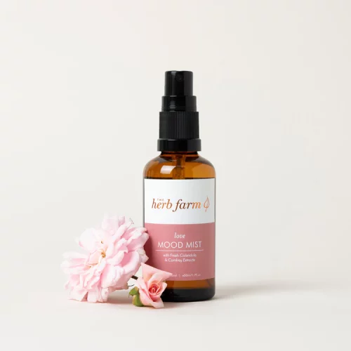 HerbFarm Mood Mist Love 50ml next to a rose flower.