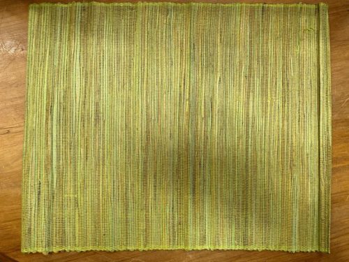a Voodoo Woven Placemat Dusty Green on a wood table