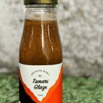 a bottle of DrippingBowl Tamari Glaze 250ml sitting on grass