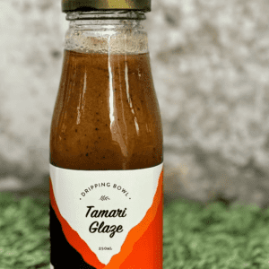 a bottle of DrippingBowl Tamari Glaze 250ml sitting on grass
