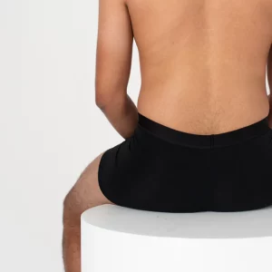A man sitting down wearing Nisa Jules Men Boxer Brief Naturals Black coloured