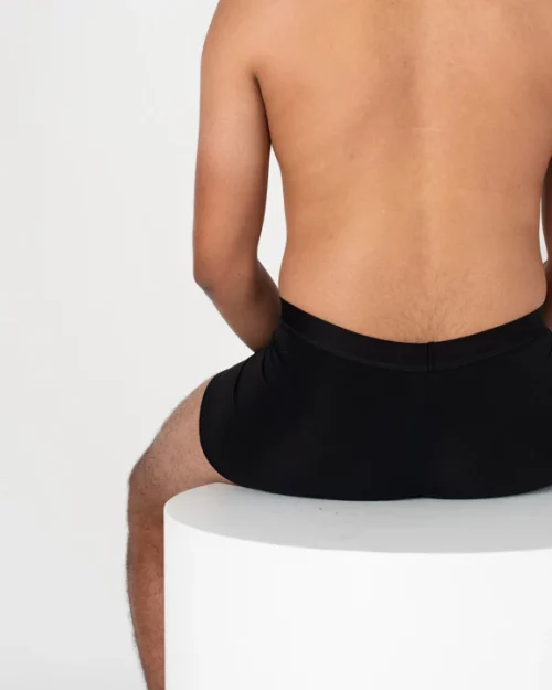A man sitting down wearing Nisa Jules Men Boxer Brief Naturals Black coloured