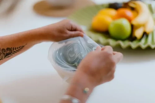 Two hands stretching a CaliWoods Silicone Stretch Lid Large onto a container