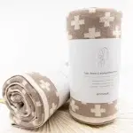 two Ecovask Hair Travel Towel Hummus Chevron rolled up in their packaging laying on a table