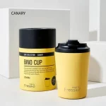 Fressko Bino Coffee Cup Canary 230ml next to its packaing