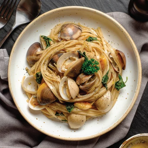 a bowl of clam pasta made with PerfectEarth Rice Pasta Brown 225g