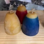 Hohepa Bell Candle of different colors, tan, blue, and red/tan