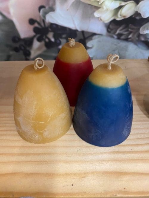 Hohepa Bell Candle of different colors, tan, blue, and red/tan