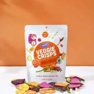 a bag of Shary Veggie Crisps Mixed Veggie 45g on a table surrounded by its veg crisp
